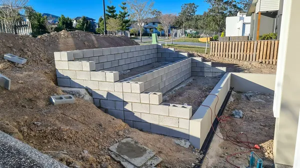 Block retaining wall under construction on a sloping block