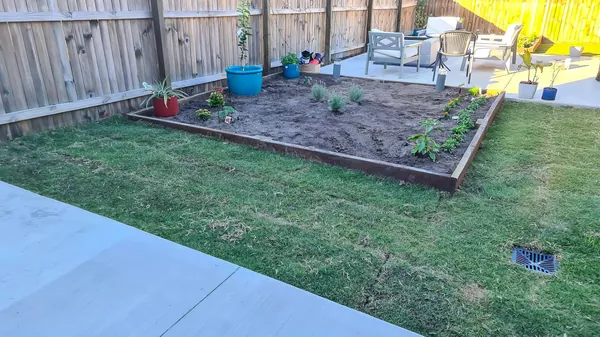 Raised garden bed, fresh lawn and patio in a finished backyard