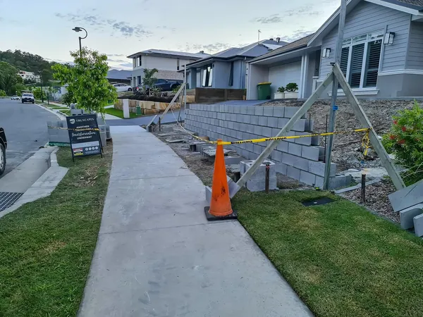 Finished block retaining wall and concrete path along a front yard