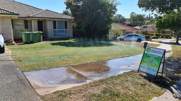 Freshly laid turf and a new concrete path in a front yard